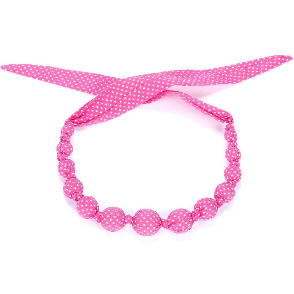 Pink polka dot necklace with matching headband on a white background