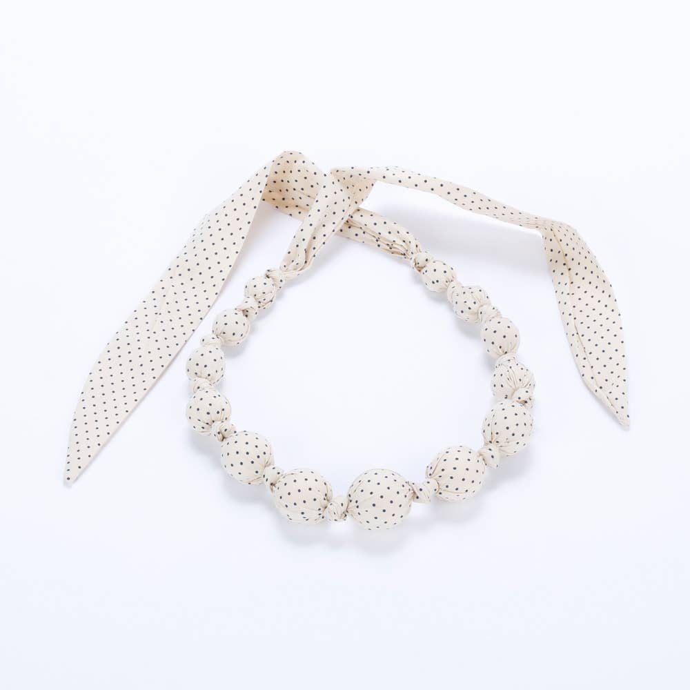 Necklace with textured beads and a matching scarf on a white background